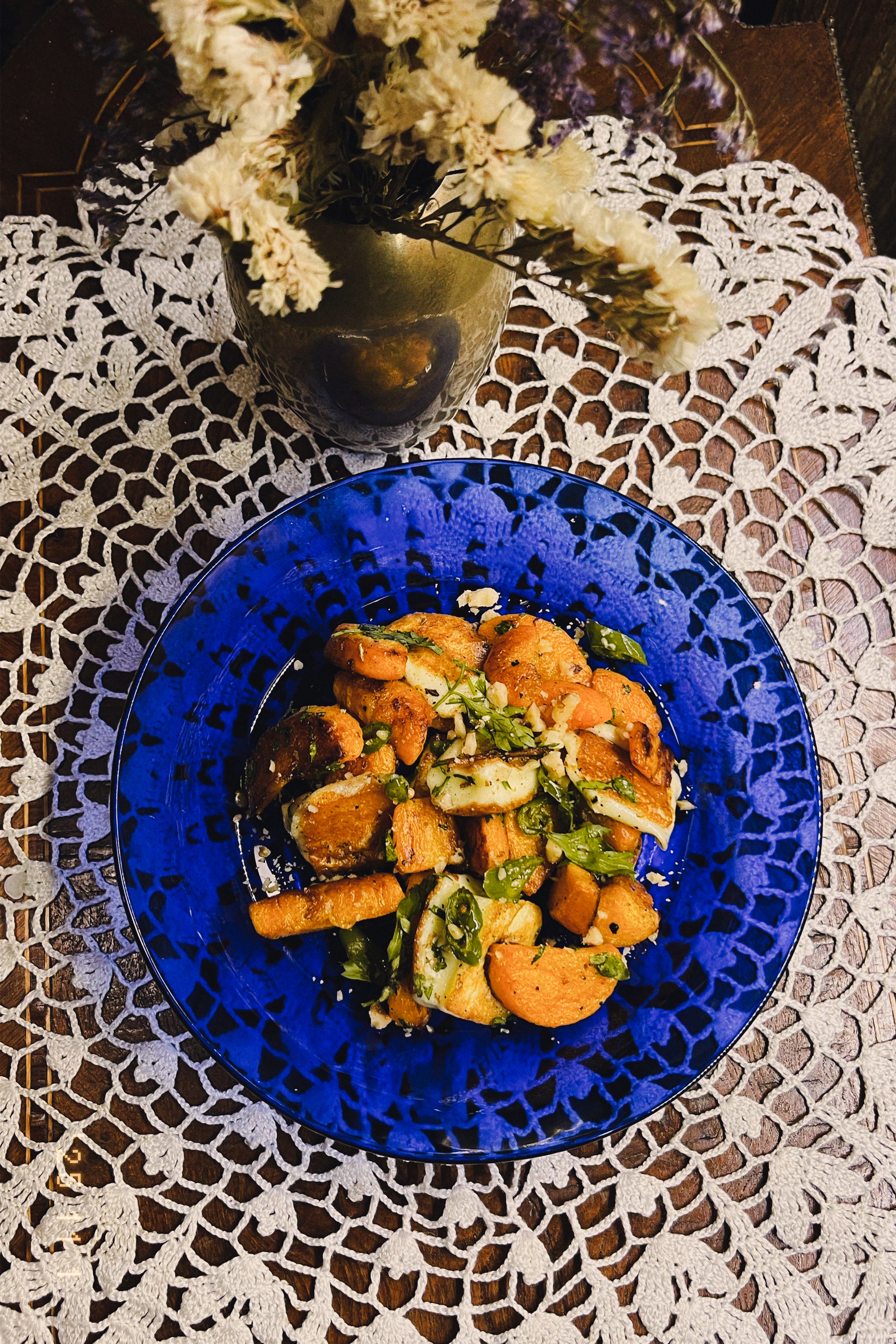 Roasted carrots and halloumi dressed with herbs on a blue plate