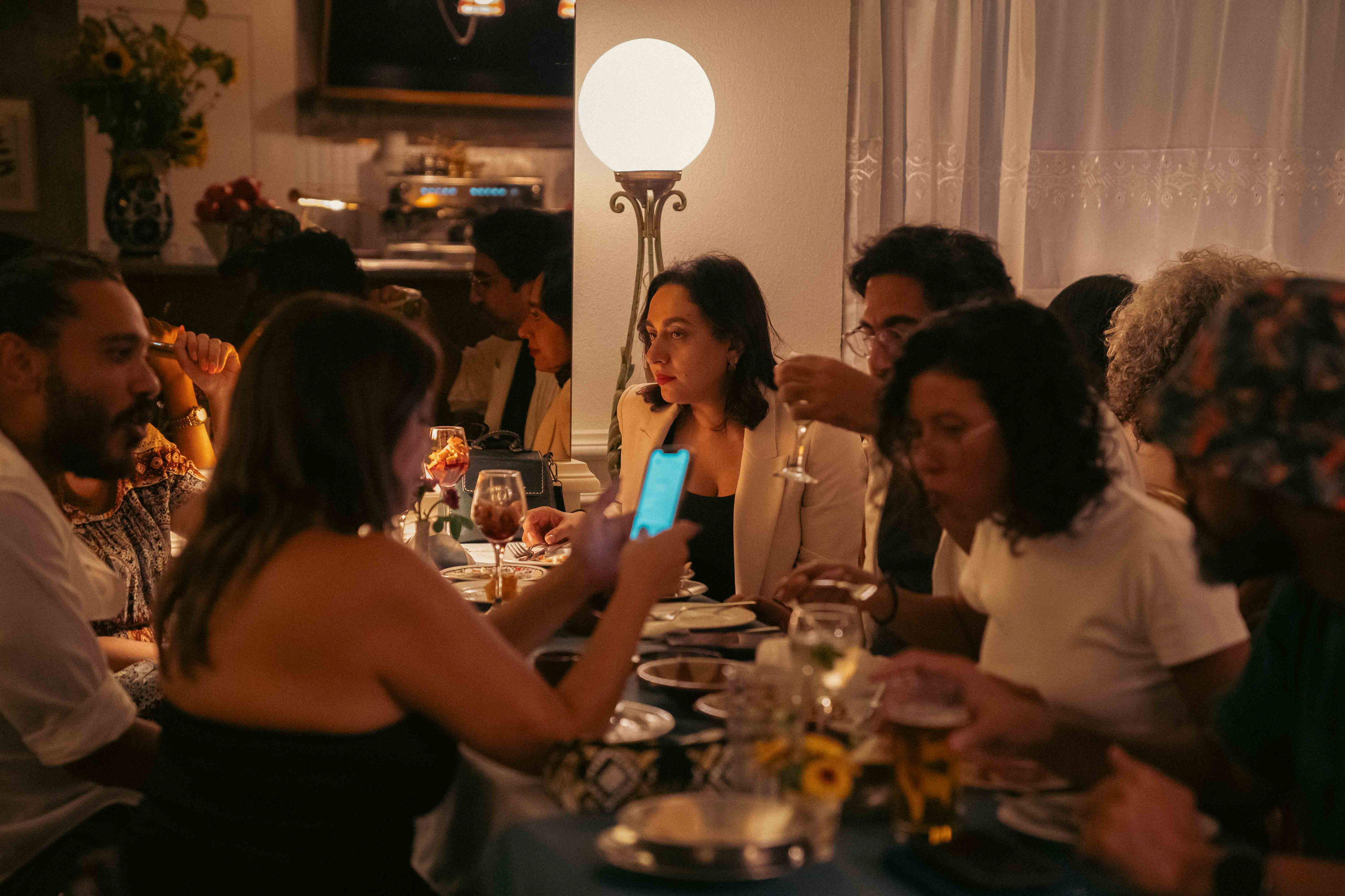 Friends gathered around a long candlelit dinner table at Almería