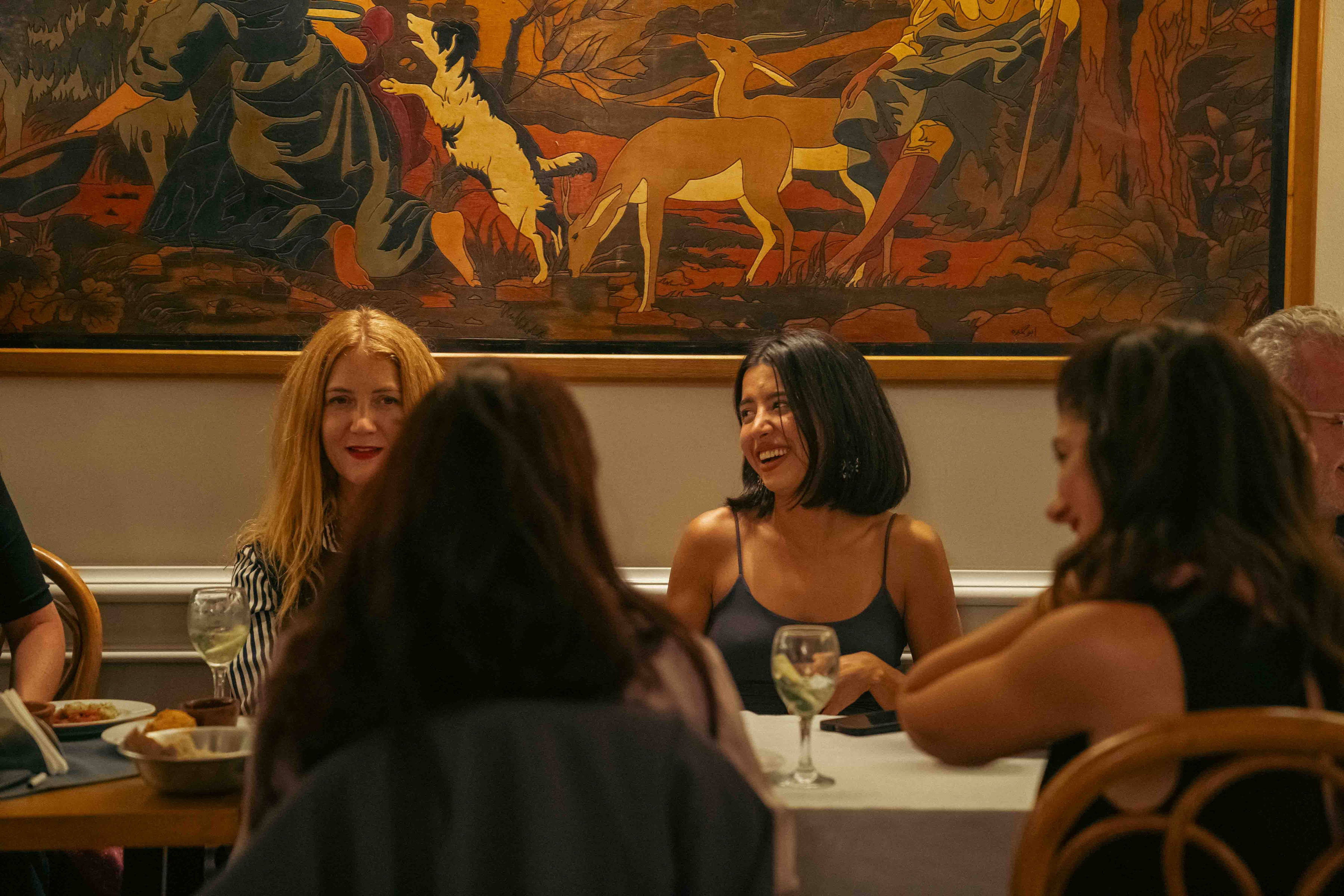 Guests laughing beneath Almería's hand-painted hunting mural