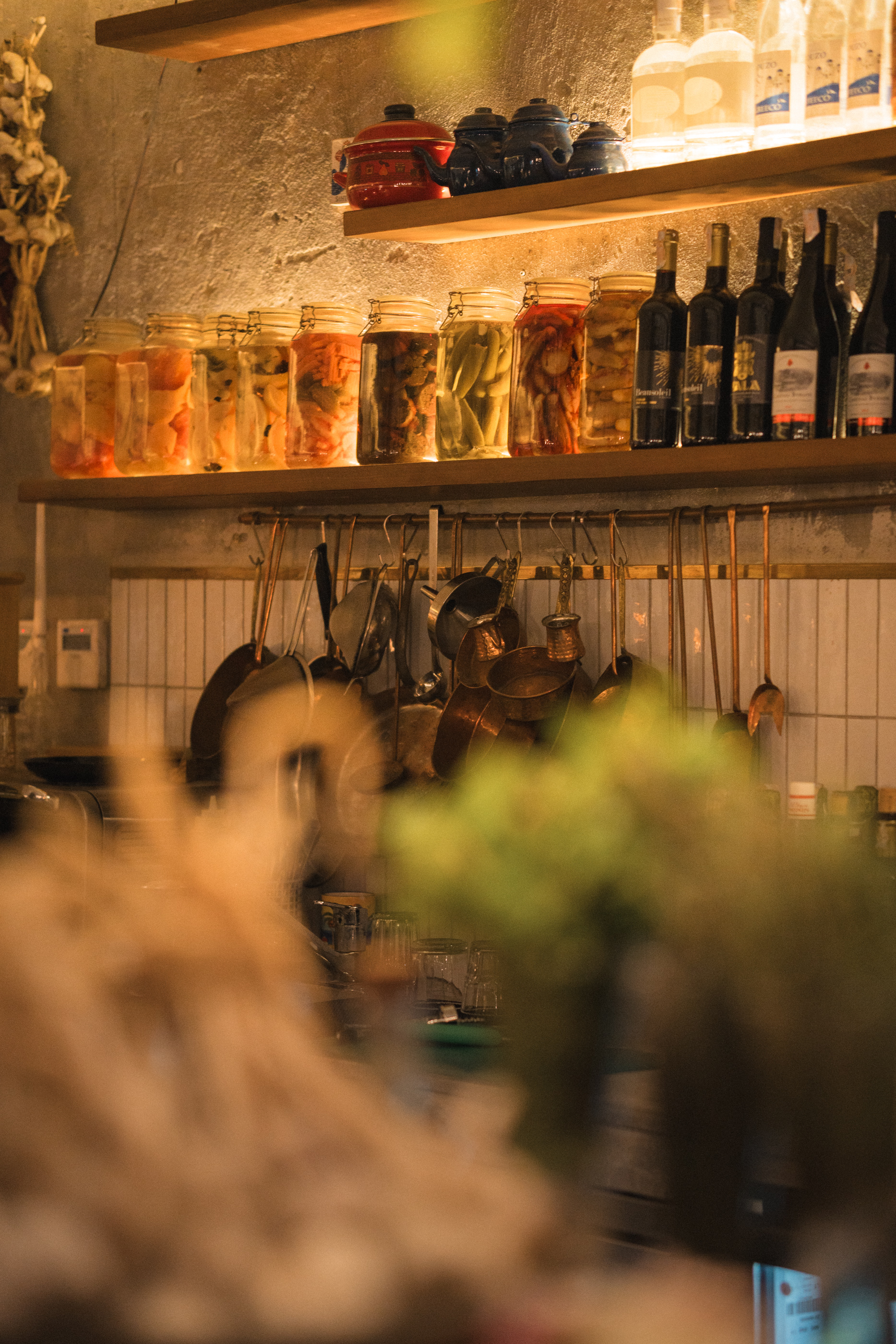 Shelves of house-made pickles, copper pots and wine at Almería