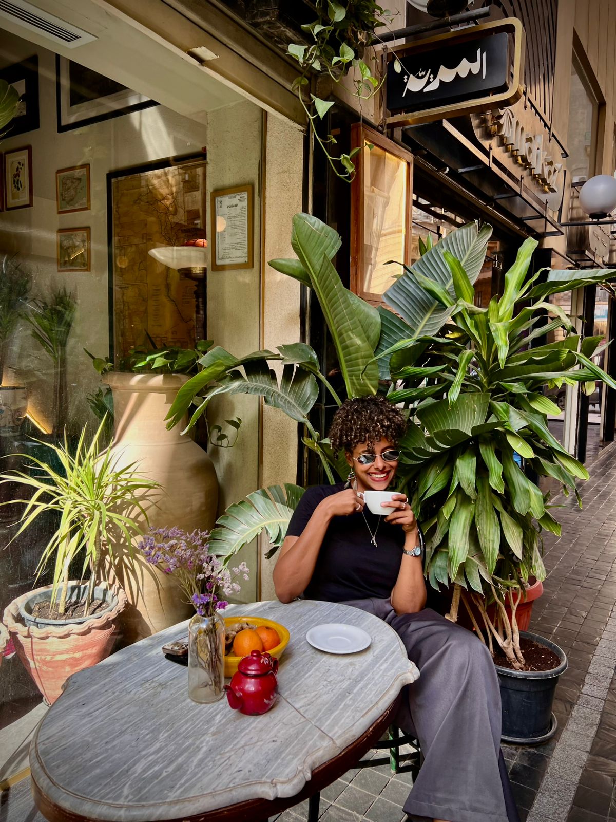 A guest enjoying coffee at Almería's leafy streetside table